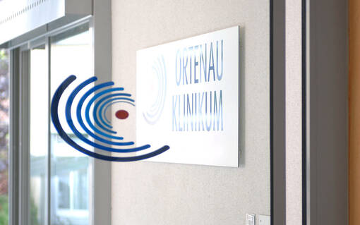 Bild mit veraltetem Logo auf einer Glastür im Ortenau Klinikum